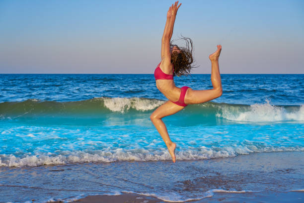 istock acrobatic gymnastics bikini girl in a beach 1345071259