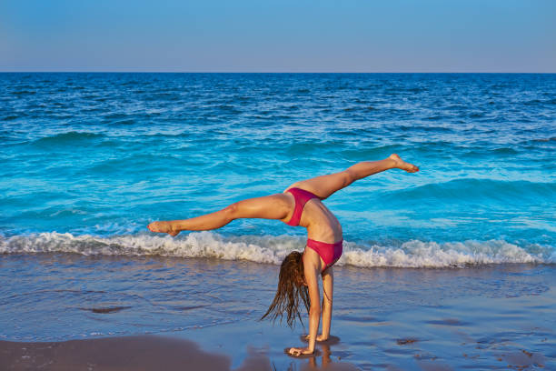 istock acrobatic gymnastics bikini girl in a beach 1345071294
