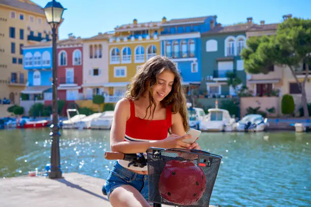 Girl riding a foldable e-bike in a Mediterranean marina port ebike