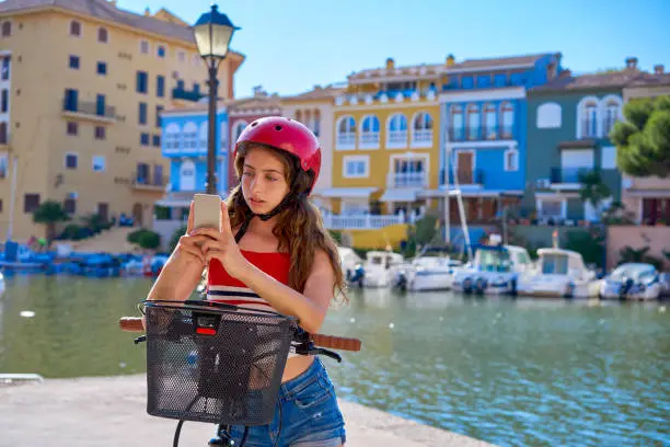 Girl riding a foldable e-bike in a Mediterranean marina port ebike