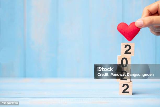 Business Man Hand Holding Red Heart Shape Over 2022 Wooden Cubes On Blue Table Background With Copy Space For Text Business Resolution New Year New You And Happy Valentineu2019s Day Holiday Concept Stock Photo - Download Image Now