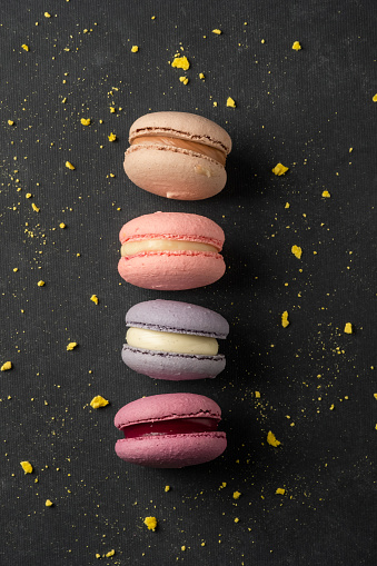 Multicolored macaroon on a dark background with copy space.