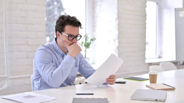 istock Pensive Young Man Thinking and Writing on Paper 1345080093