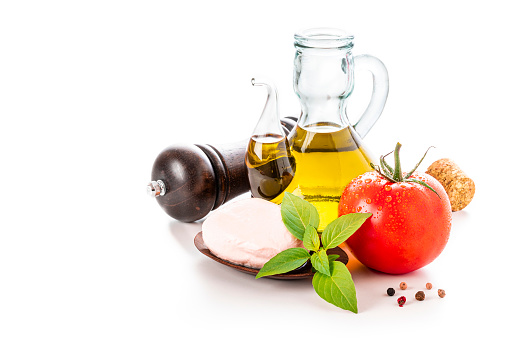 Front view of various Italian ingredients isolated on white background. The composition includes an olive oil bottle, mozzarella, tomato, basil and pepper