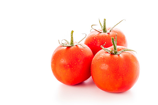 Front view of three wet tomatoes isolated on white background