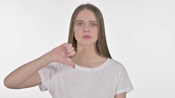 istock Thumbs Down by Beautiful Young Woman, White Background 1345087968