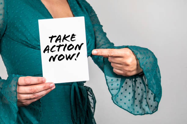 istock Take Action Now. Woman points a finger at the text 1345088120