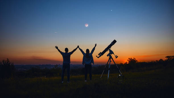 istock Couple stargazing together with a astronomical telescope. 1345088865
