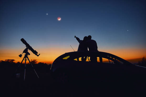 istock Couple stargazing together with a astronomical telescope. 1345088924