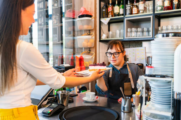 istock Young woman with Down Syndrome working at cafe 1345088980