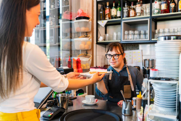 istock Young woman with Down Syndrome working at cafe 1345089020