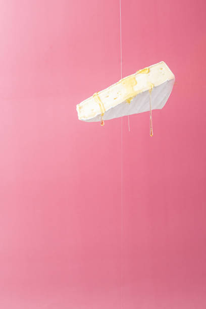 istock Brie cheese with honey on a pink background. Flying cheese 1345089343