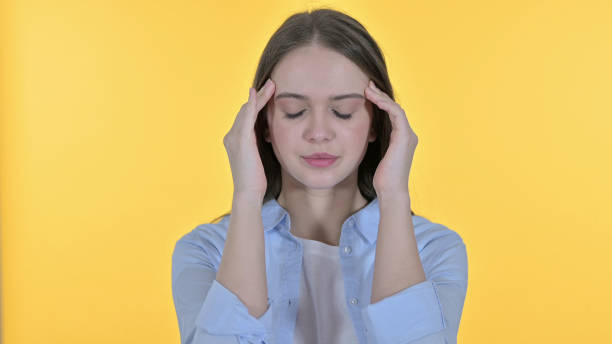 istock Casual Young Woman with Headache, Yellow Background 1345089461