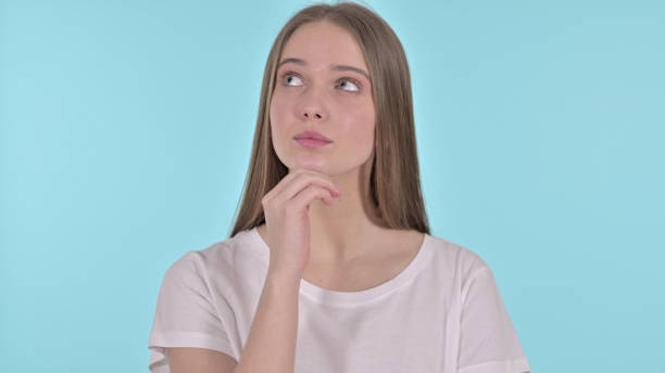 istock Pensive Beautiful Young Woman Thinking New Idea, Blue Background 1345089784