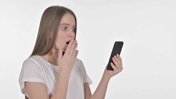 istock Beautiful Young Woman Facing Loss on Smartphone, White Background 1345090385