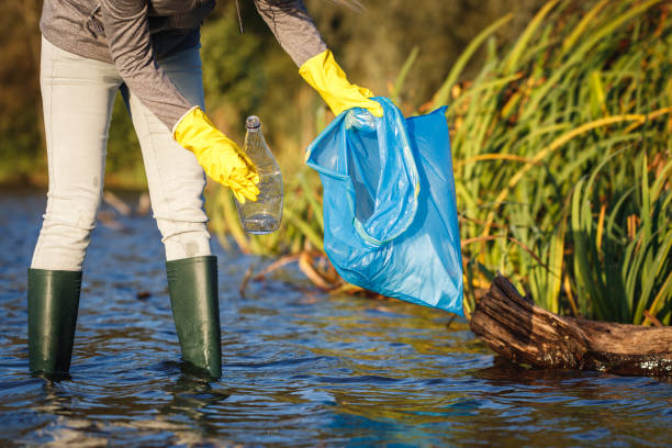 istock Environmental volunteer cleaning water in nature from plastic waste 1345092389