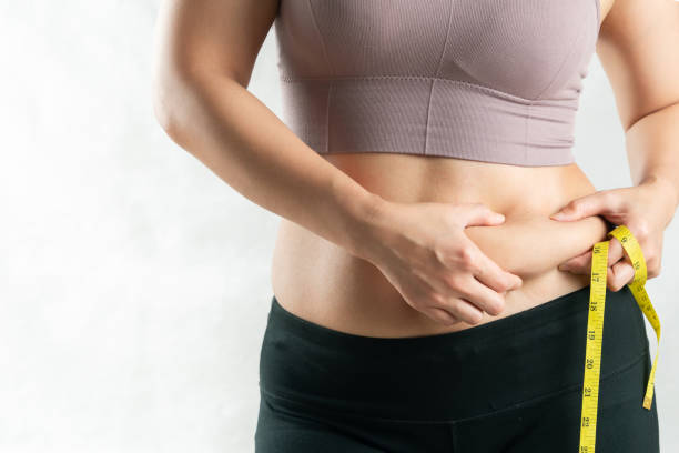 fat woman, fat belly, chubby, obese woman hand holding excessive belly fat with measure tape, woman diet lifestyle concept - buik stockfoto's en -beelden