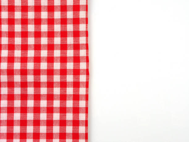 istock Top view, close-up of red and white checkered fabric or napkin on white table background. Concept kitchen utensils and tableware. 1345093627