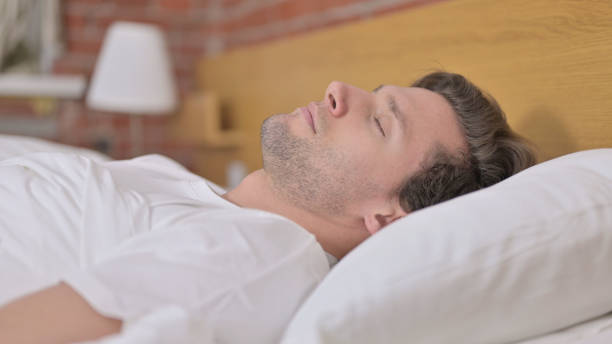 istock Portrait of Young Man Sleeping in Bed 1345094486