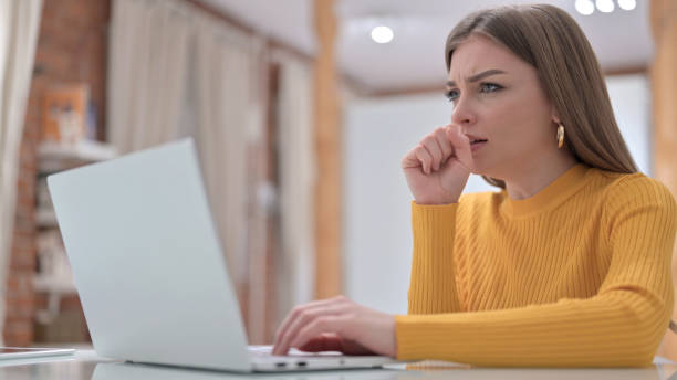 istock Sick Young Creative Young Woman Coughing in Office 1345095150