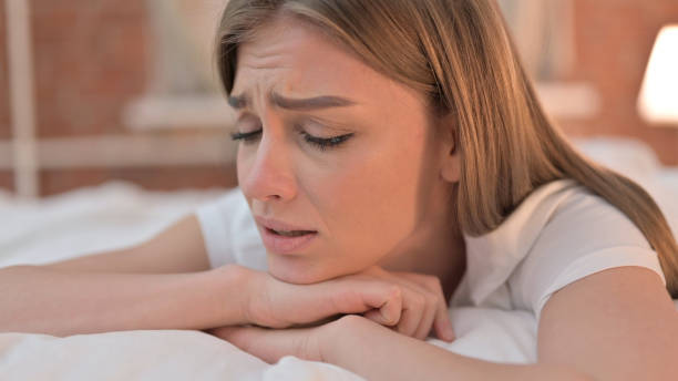 istock Sad Young Woman Crying in Bed 1345097469