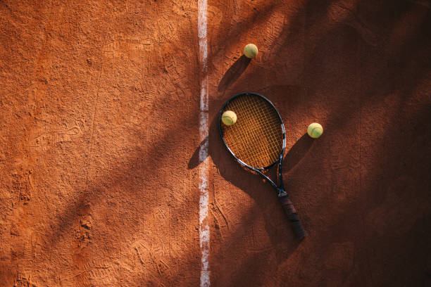 racchetta da tennis e palline da tennis su campo in terra battuta - racchetta foto e immagini stock