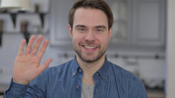 istock Portrait of Young Man Waving at Camera 1345098496