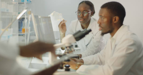 istock Diverse team working in modern laboratory. Woman and man discussing during research 1345098751