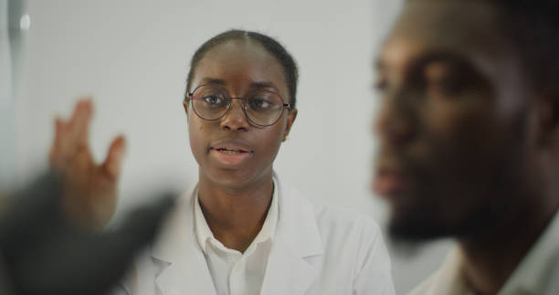 istock Diverse team working in modern laboratory. Woman and man discussing during research 1345098907