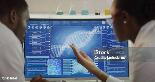African Ethnicity Scientists Studying Dna Samples Computer Screens With Dna Sequences Discussing Stock Photo - Download Image Now