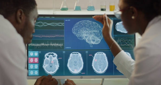 istock Laboratory equipment and computers. Brainwave research on screens. African ethnicity scientists discussing 1345098986