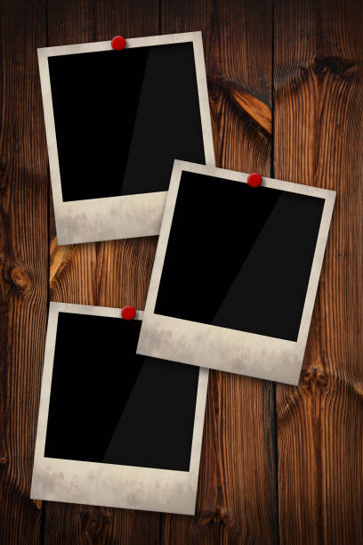 istock Empty instant photo frames pinned on wooden wall 1345099189
