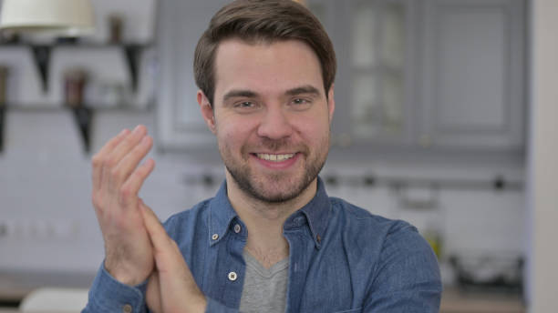 istock Portrait of Beard Young Man Smiling and Clapping 1345099190