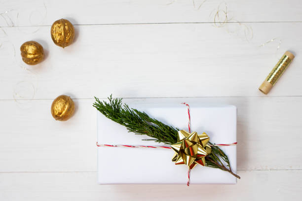 istock Box with a Christmas present on a white wooden background. Top view, place for text. 1345099836