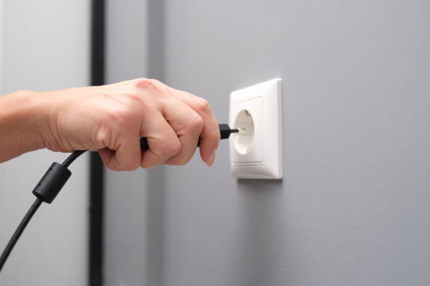 la mano de la mujer inserta un enchufe eléctrico en el primer plano de la toma de corriente - electric plug outlet pulling electricity fotografías e imágenes de stock