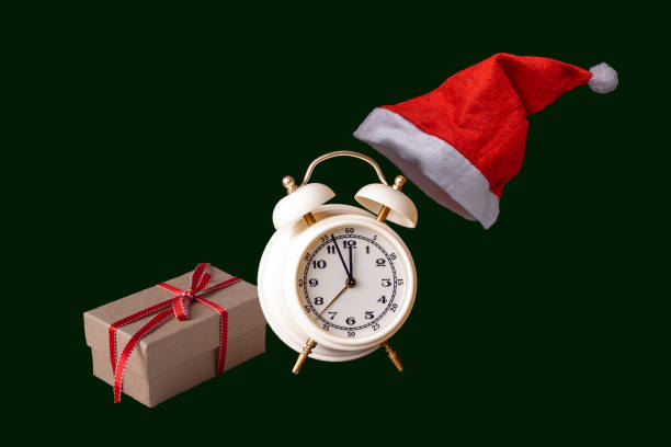istock gift, alarm clock, Santa hat on a green background 1345101906