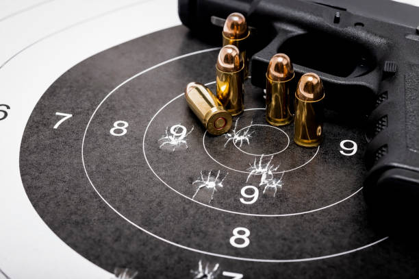 istock Gun bullets on bull eye paper target and semi automatic handgun background 1345102985