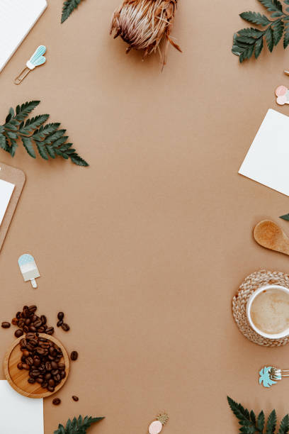 istock Top view brown neutral workspace office desk with coffee and office supplies. Flat lay work table with craft notebook, green olive leaf and supplies. Home blogger 1345107012