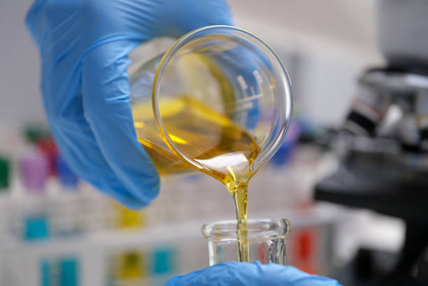 chimiste versant de l’huile comestible de la fiole dans un gros plan de tube à essai - test tube laboratory chemical science photos et images de collection