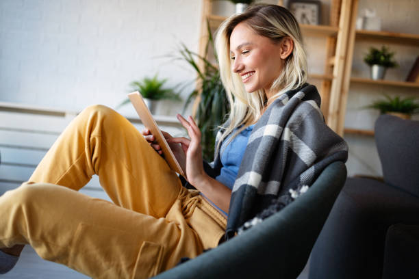 istock Happy young woman using tablet pc in loft apartment 1345110152