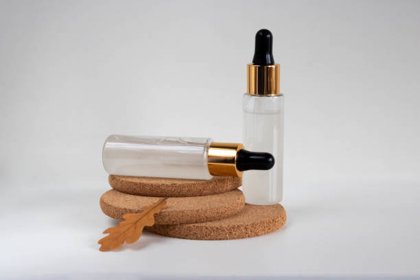 istock Two frosted bottles with a pipette, isolated on cork stands on a white background. The layout is suitable for cosmetics design 1345111393