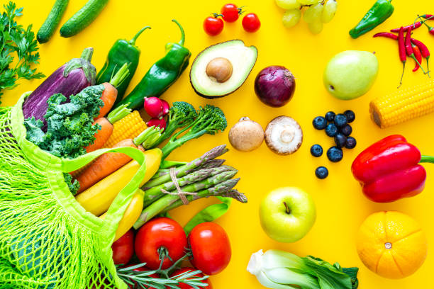 istock Fruits and vegetables on yellow backdrop 1345114423