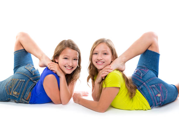 twin kid sisters symmetrical flexible playing happy twin kid sisters symmetrical flexible playing happy on white background acrobatic gymnastics stock pictures, royalty-free photos & images