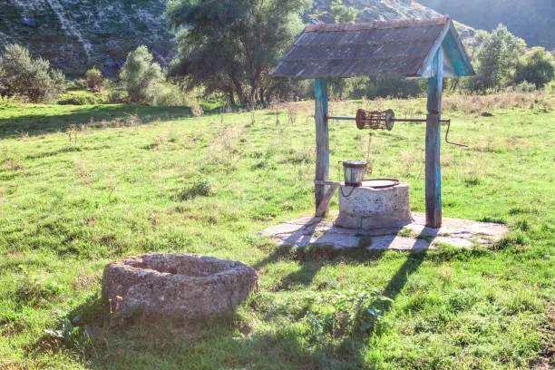 Rustic Source of drinking water . Well on the meadow in the village