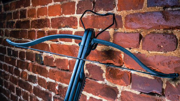 istock A modern compound crossbow handgun on the red brick wall background. Old weapon concept. 1345121747