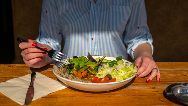 istock Girl eating a healthy salad on a rustic table close up 1345123025