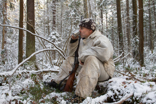 istock hunter sitting and drinking tea in the winter forest 1345124459