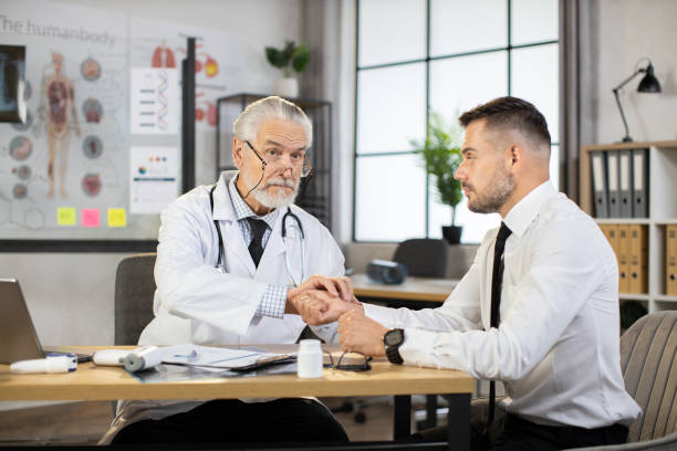 istock Senior doctor measuring pulse on patient wrist 1345126933