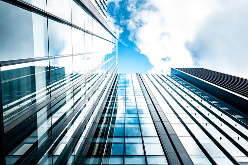 View of high rise glass building and dark steel window system on blue clear sky background