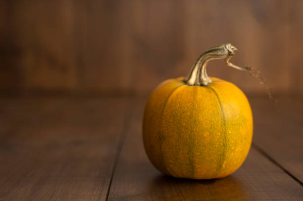 istock Pumpkin on the brown wooden background horizontal 1345130999
